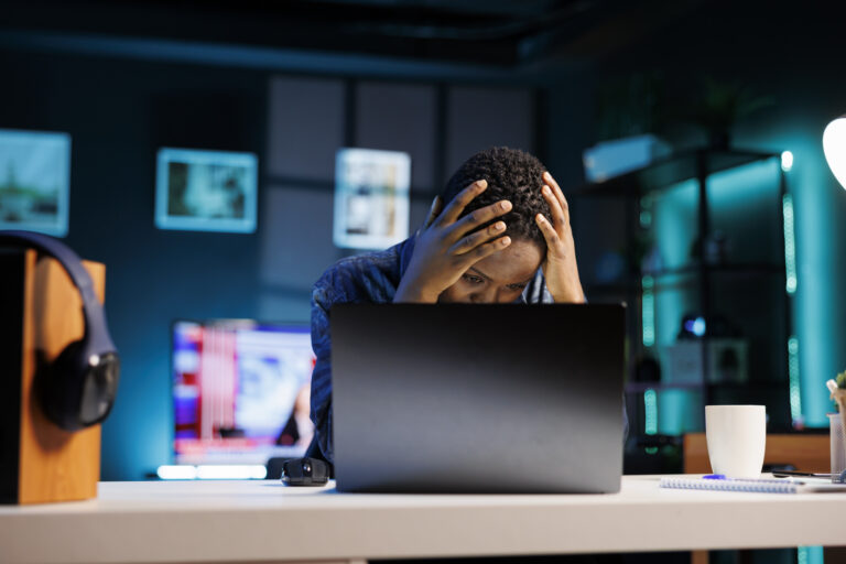 Frustrated woman using modern laptop