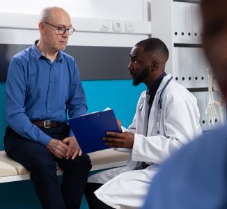 Specialist physician doctor explaining sickness expertise to retired old man discussing healthcare treatment in hospital office. Senior patient having medical appointment. Medicine concept